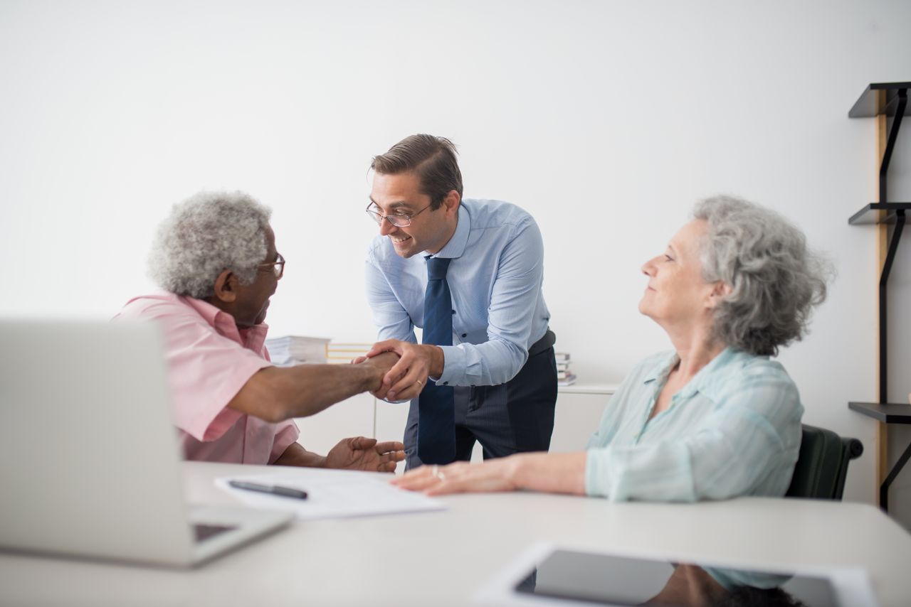 our-stories Business professional meeting with senior clients in an office setting, showcasing diversity and cooperation.